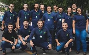 Equipe da Ecoinset reunida ao ar livre, todos de uniforme azul-marinho com o logo da empresa.